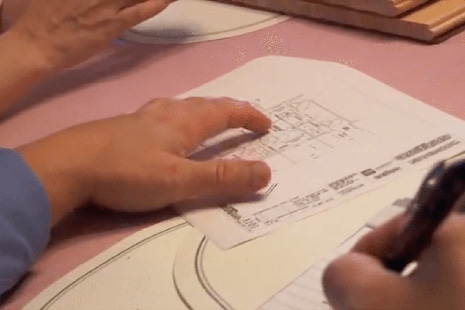 Person sketching on blueprints