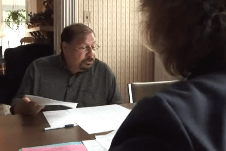 Man sitting at table reading papers