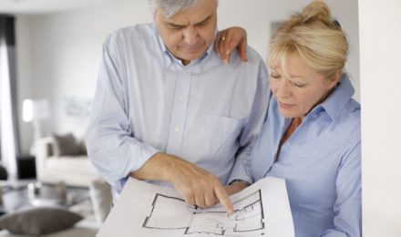 Senior couple looking at blueprint for their home
