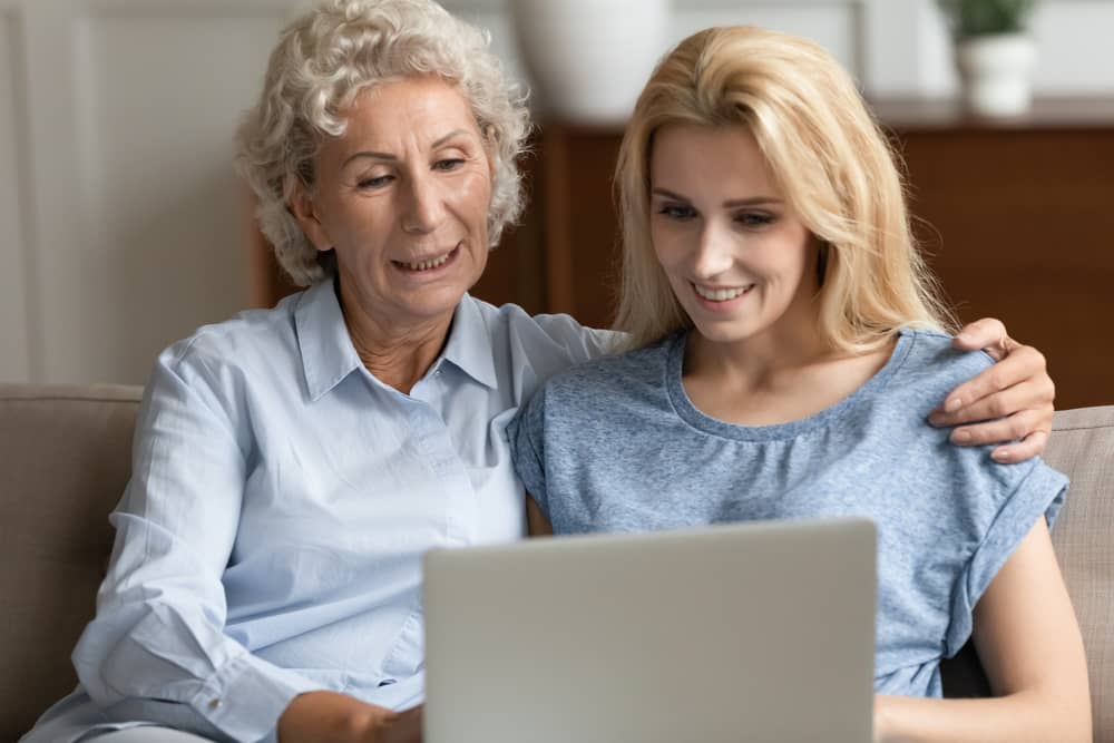 adult daughter with mother laptop