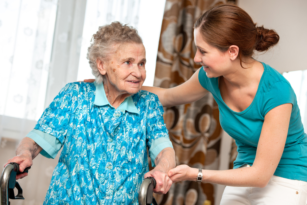 A caregiver assisting an elderly woman.