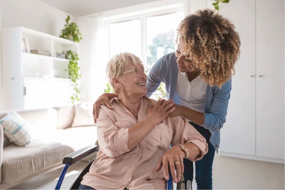 woman comforting older woman in a wheelchair 