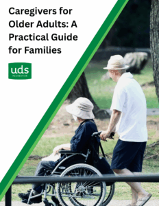 Cover Page of Caregiver Guide with Man Pushing a Woman in a Wheelchair